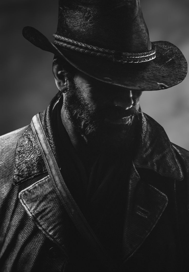 a black and white photo of a man wearing a cowboy hat