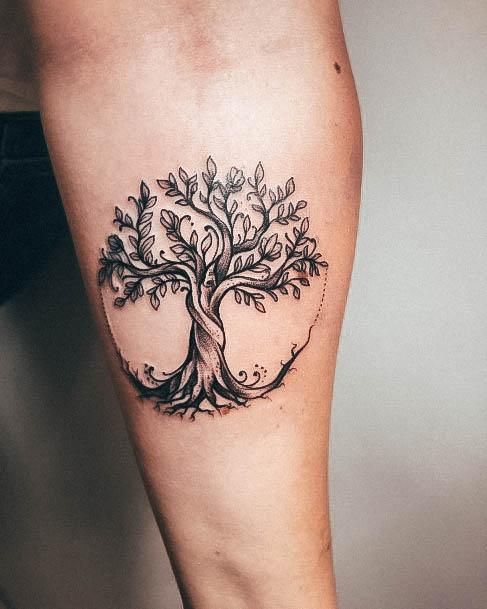 a woman's leg with a tree tattoo on it