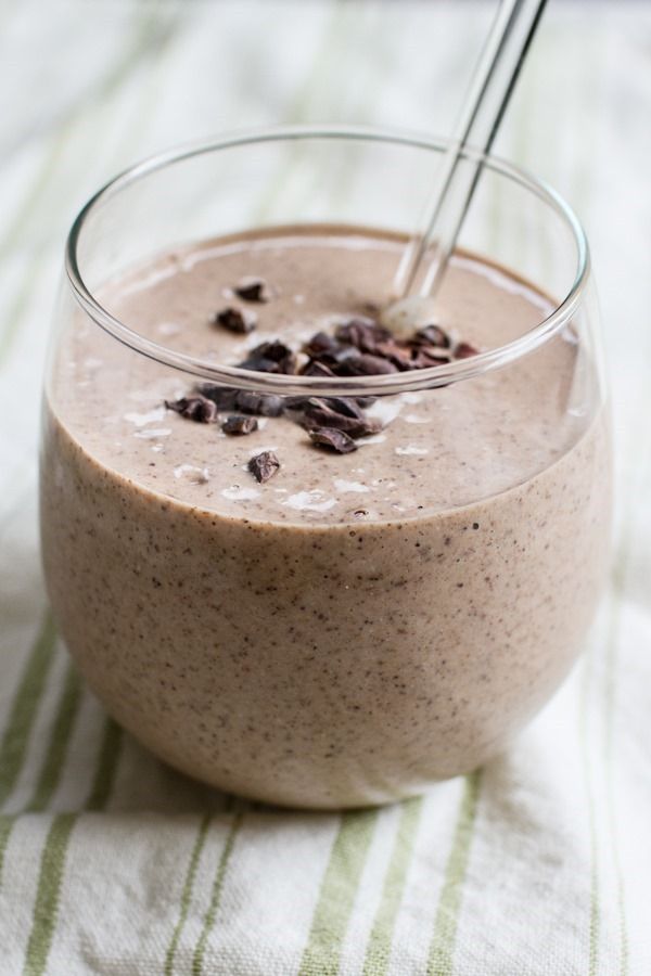 a smoothie in a glass bowl with a straw sticking out of it's top