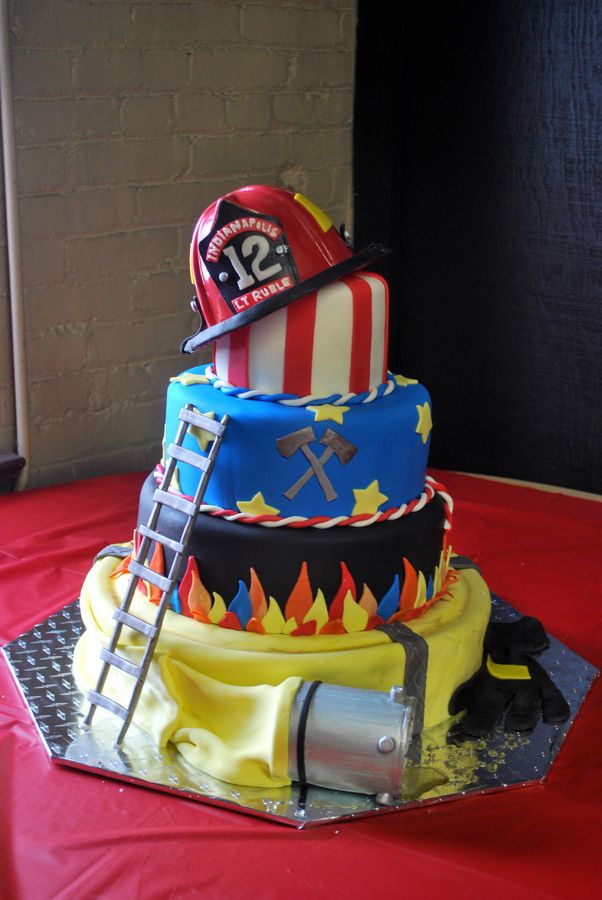 a fireman's hat and ladder on top of a cake