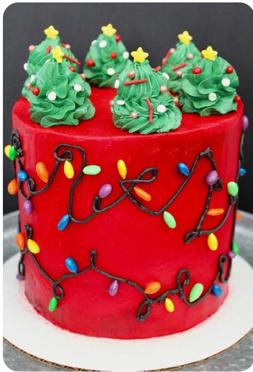 a red cake decorated with christmas trees and lights