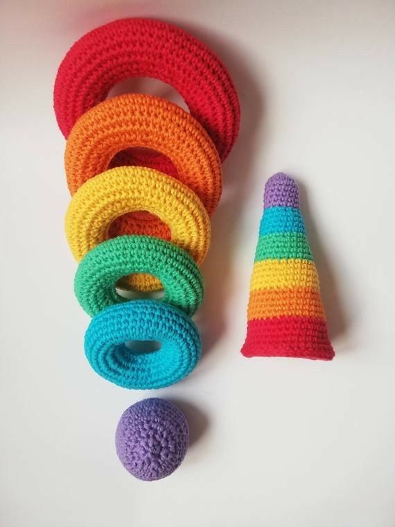 there is a crocheted hat and several colorful rings next to each other on the table