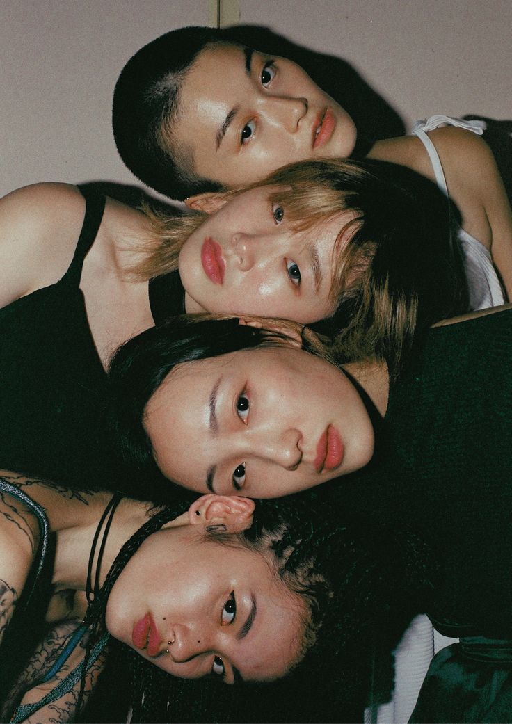 four people are laying down together in a circle with their heads turned to the side