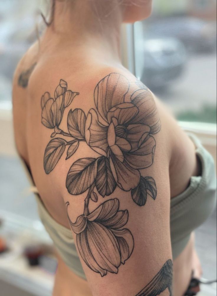 a woman's shoulder with flowers on it