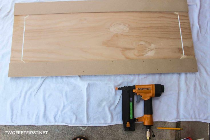 some tools are laying on top of a sheet of paper next to a piece of wood