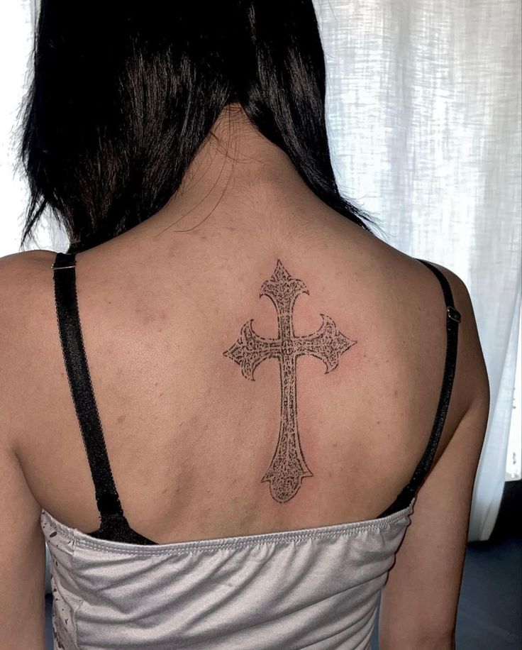 a woman with a cross tattoo on her back