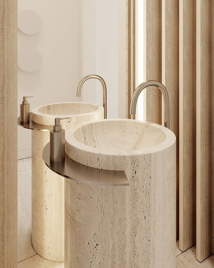 two round sinks in a bathroom next to each other with metal faucets on them