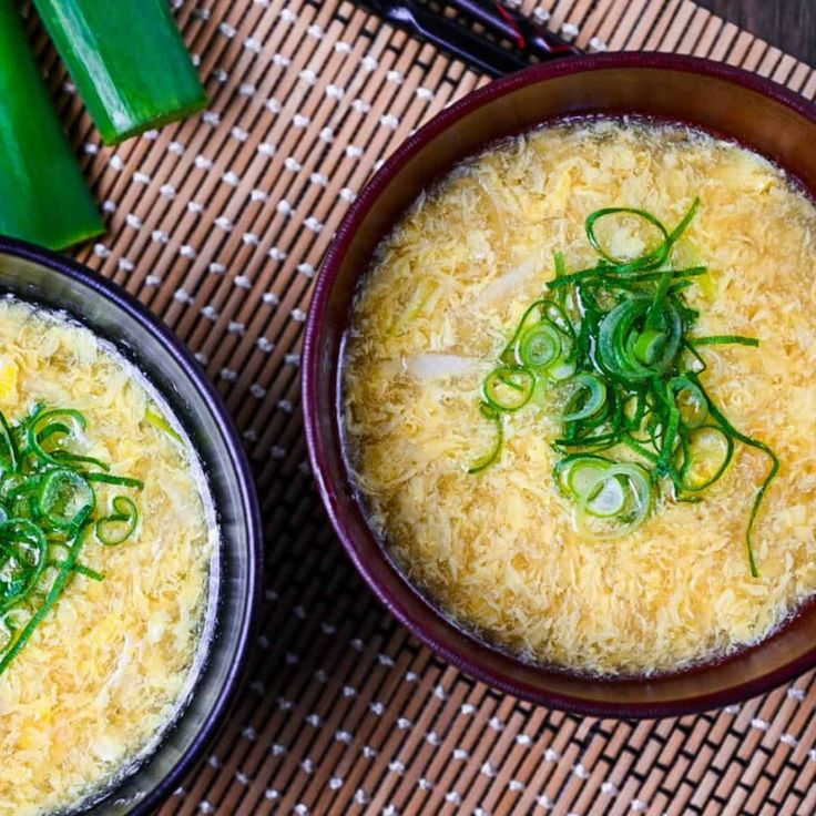 two bowls filled with food sitting on top of a mat