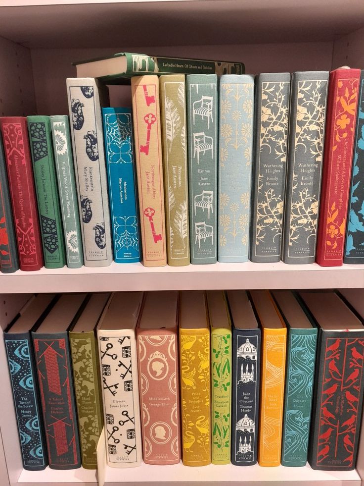 a row of books sitting on top of a white book shelf next to each other