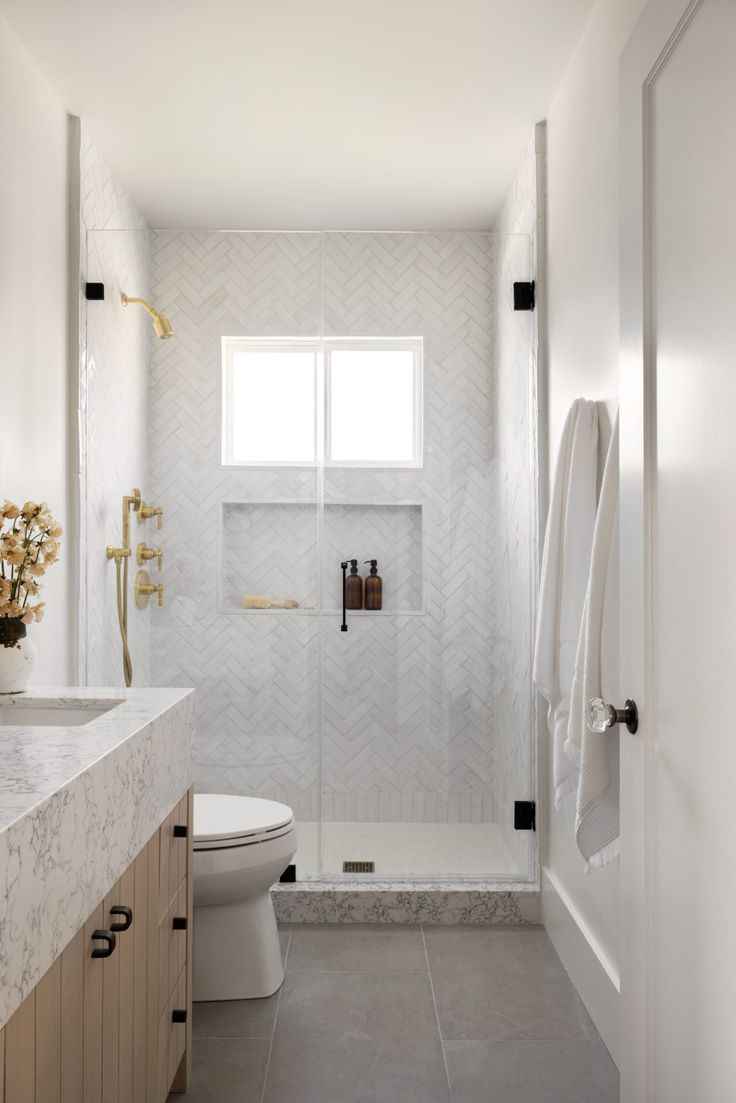 a bathroom with a toilet, sink and shower