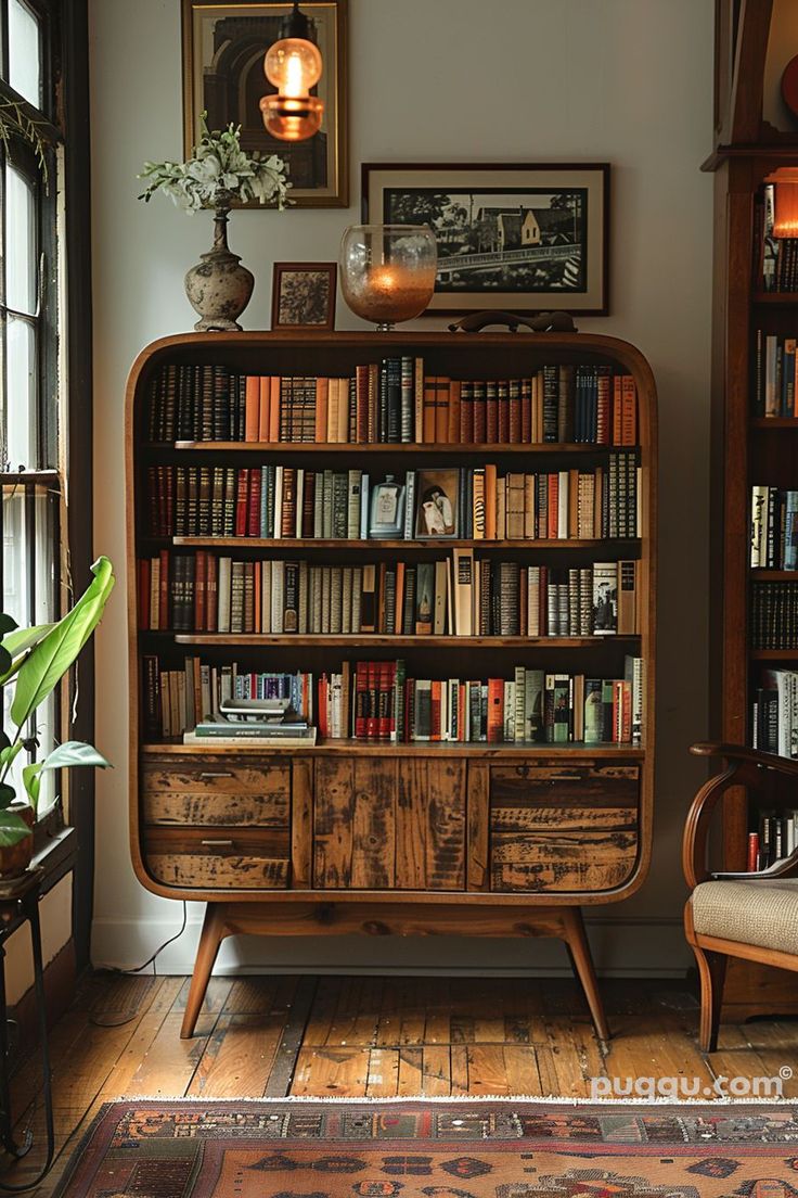 an old bookcase with many books on it in a living room next to a window