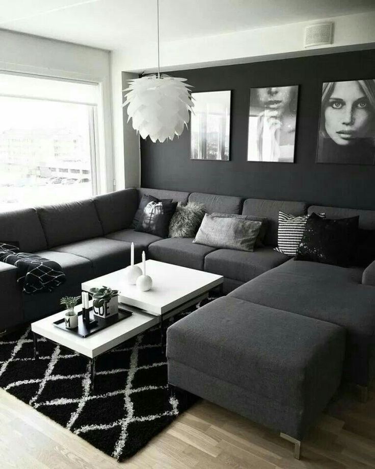 a black and white living room with couches, coffee table and pictures on the wall