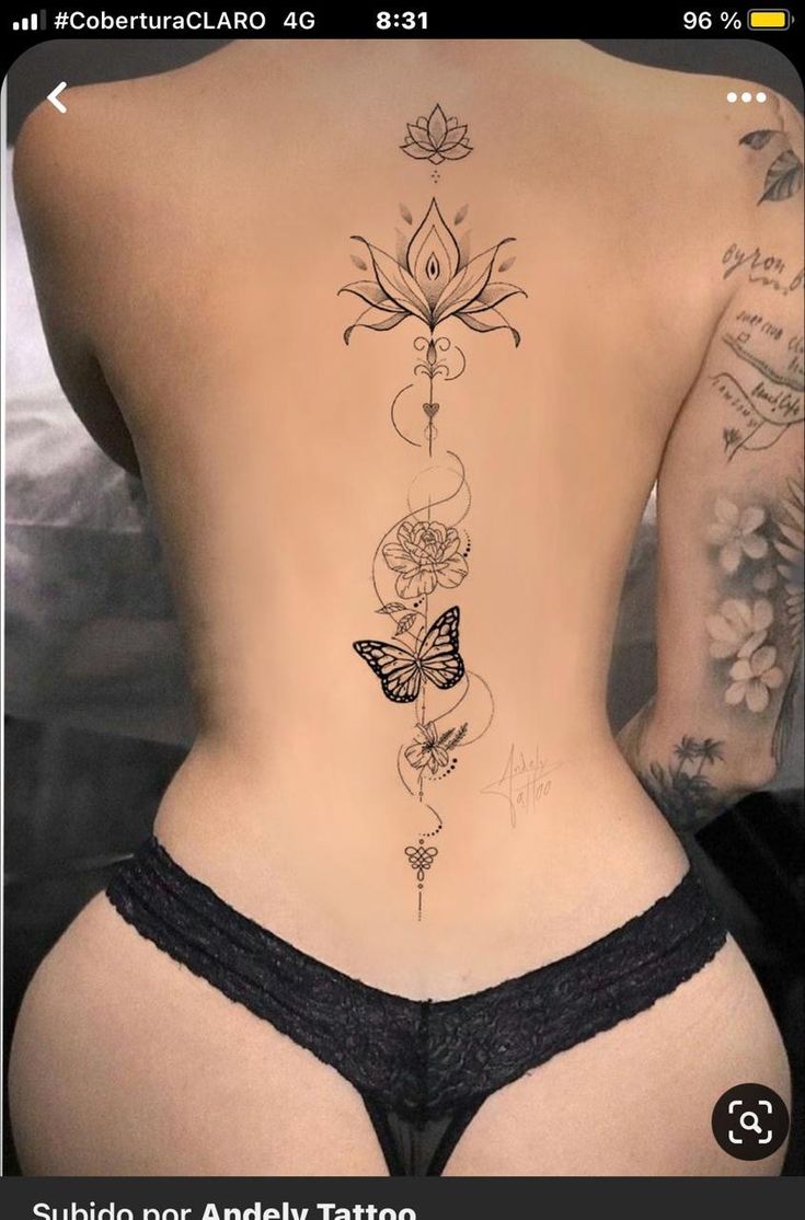 the back of a woman's body with tattoos and flowers on her side,