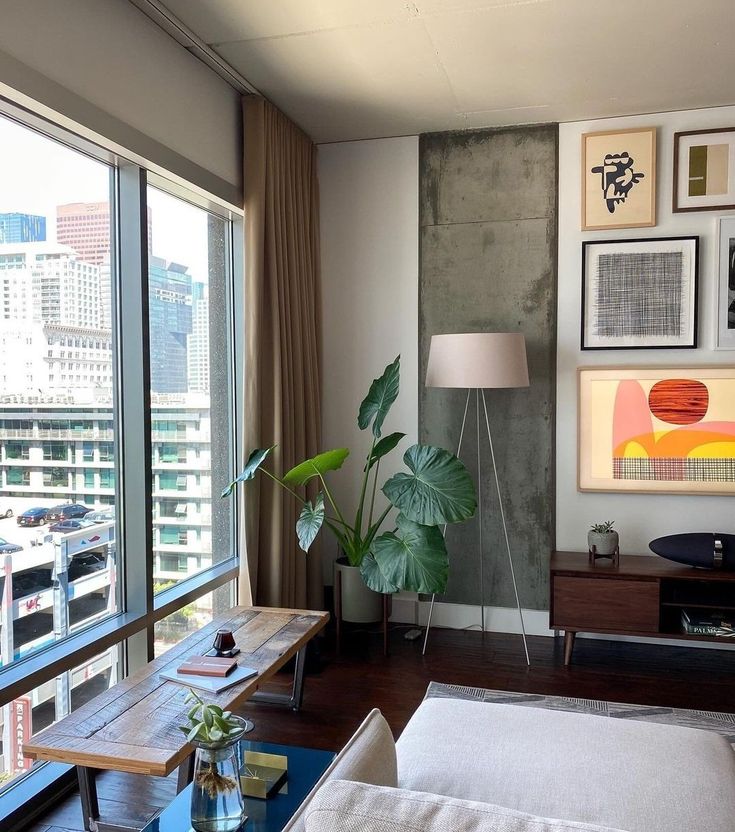 a living room filled with furniture and lots of window sill next to a large window