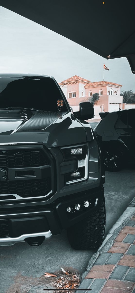 a large black truck parked in front of a building