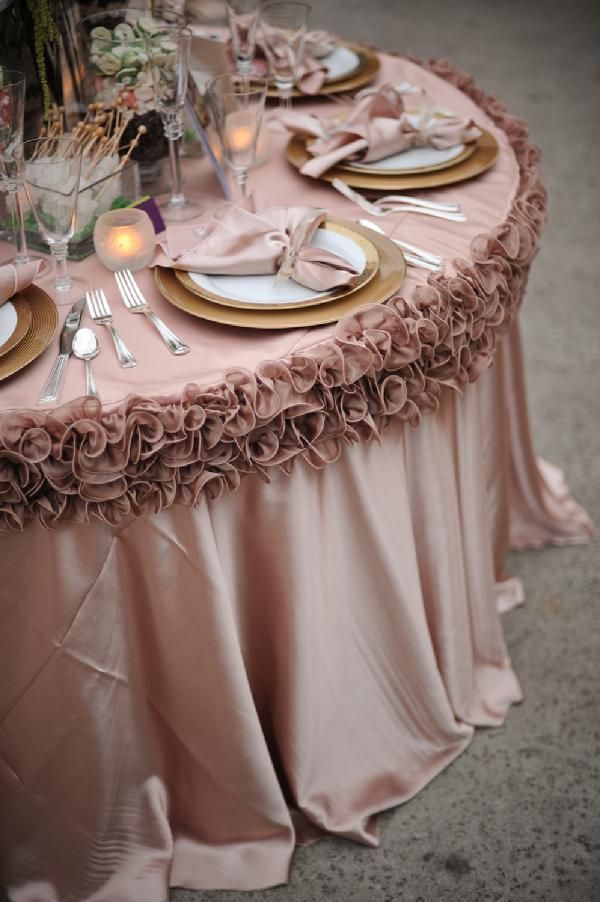 the table is set with plates, silverware and pink linens for an elegant look