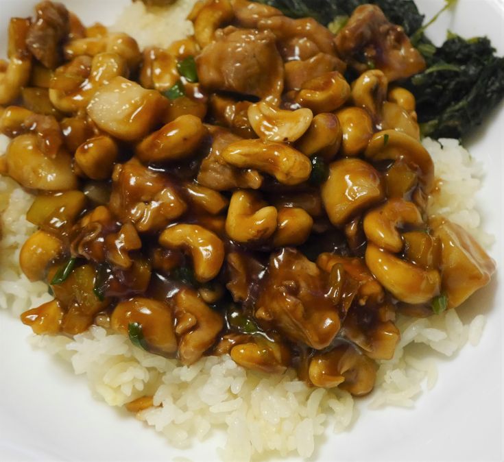 a white plate topped with rice and meat covered in sauce