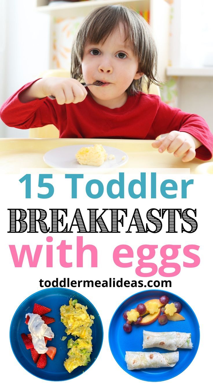 toddler eating breakfasts with eggs on a plate and in the background, there is a