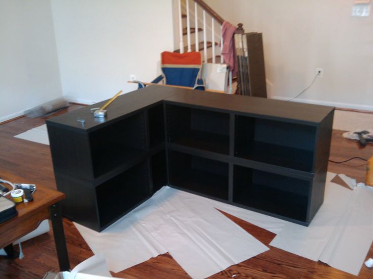 an empty room with many pieces of furniture on the floor, including bookshelves