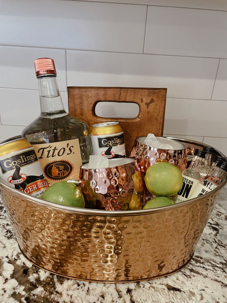 a metal bucket filled with alcohol and limes