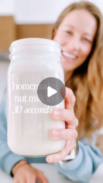 a woman holding a glass jar with the words, homemade nut mix in 30 seconds