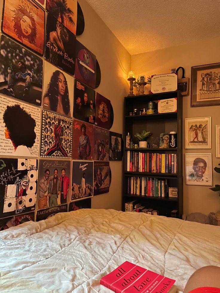 a bed with lots of pictures on the wall above it