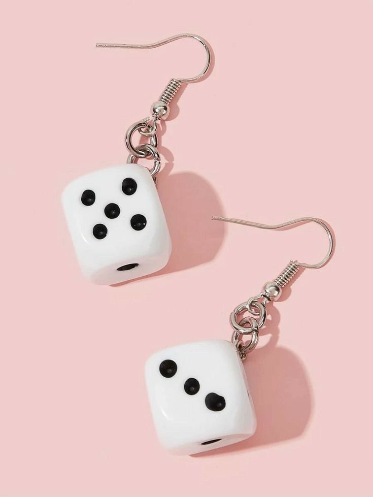 two white dices with black dots hanging from silver earwires on a pink background