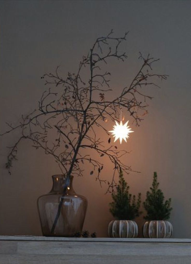 a vase and some glasses on a table with a star decoration in the background,