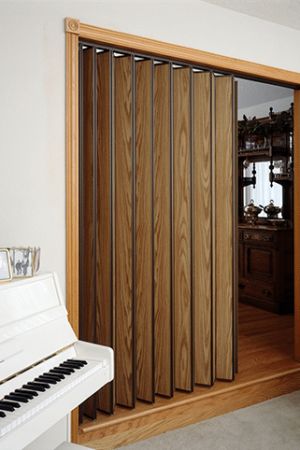 a white piano sitting in front of a wooden paneled wall with sliding glass doors