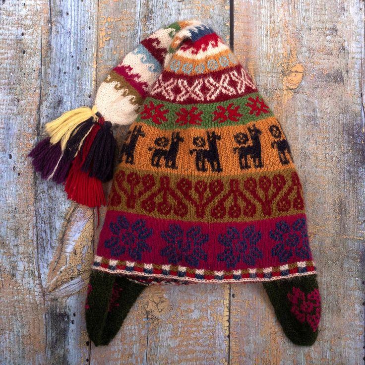 Working with pure baby alpaca wool yarns the artisans of Hilando Victoria in Peru knit this wonderful chullo hat entirely by hand. The traditional Andean-style hat features a parade of llamas and ear flaps to keep you cozy when the wind blows. A colorful tassel accents the end. Hand Knitted Alpaca Hats For Winter, Warm Alpaca Crochet Hat One Size, Winter Alpaca Hat One Size, Winter Alpaca Hats, Hand Knitted One Size Alpaca Hats, Adjustable Alpaca Beanie Hat, Bohemian Knitted Alpaca Hat, Adjustable Knitted Alpaca Hat, Warm Alpaca Beanie Hat