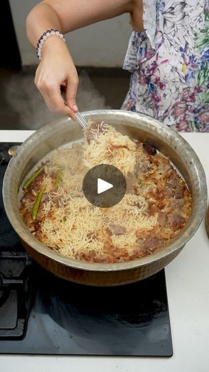 a woman is cooking pasta in a pan on the stove top with a spatula