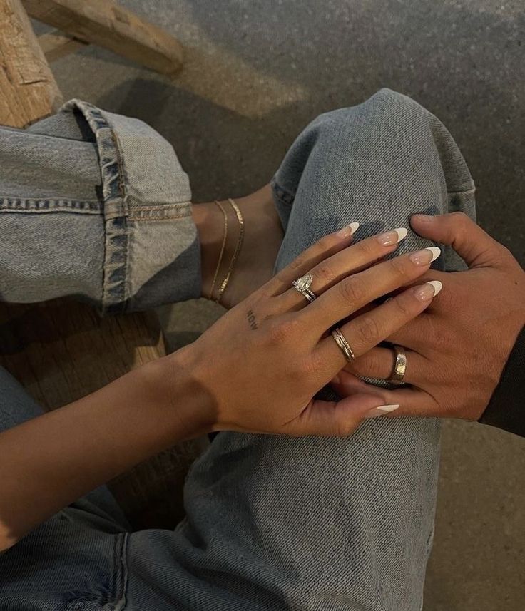 two hands holding each other while sitting on a bench