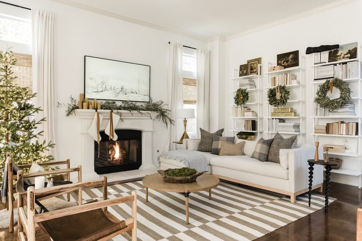 a living room filled with furniture and a fire place next to a christmas decorated tree