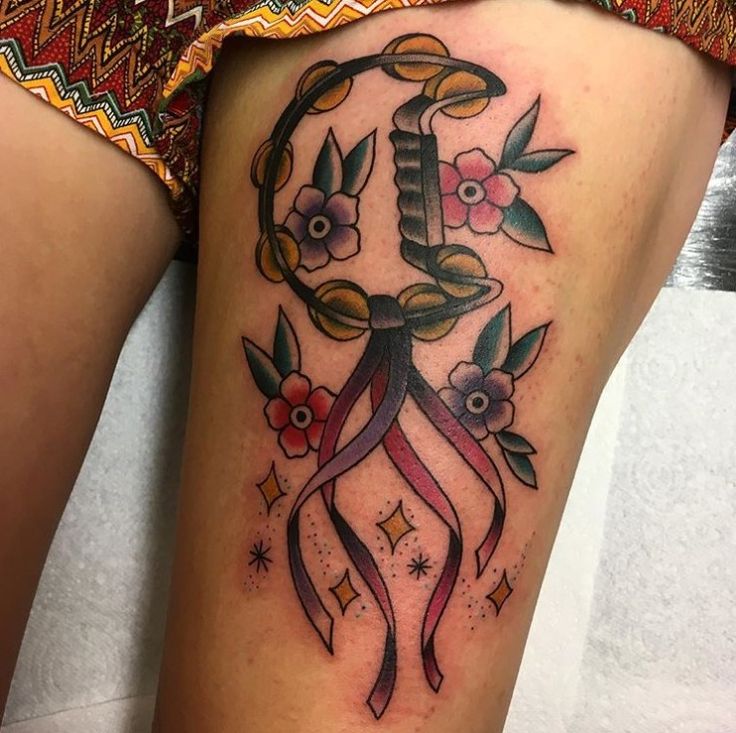 a woman's thigh with an anchor and flowers on it