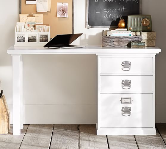 a white desk topped with a laptop computer next to a chalkboard and pictures on the wall