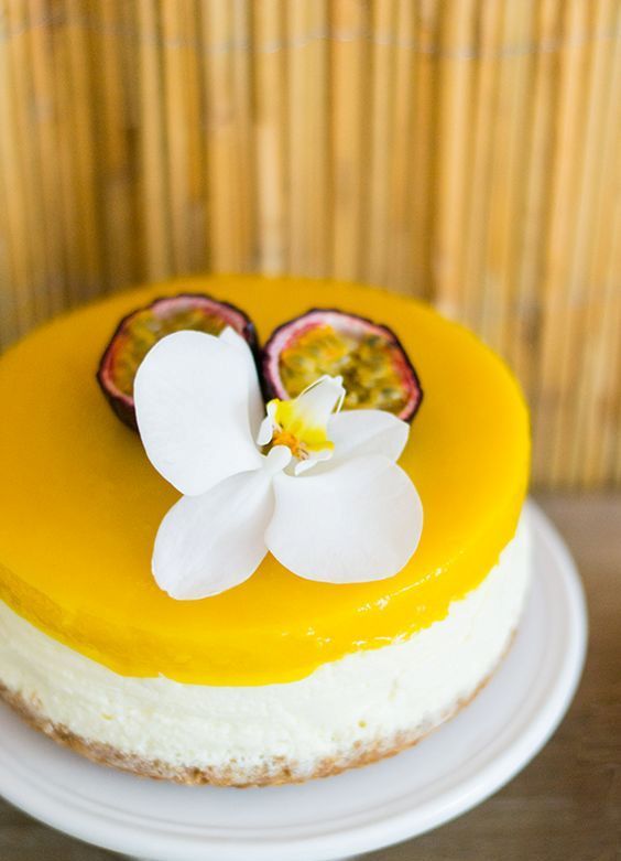 there is a yellow cake with white flowers on the top and one flower in the middle