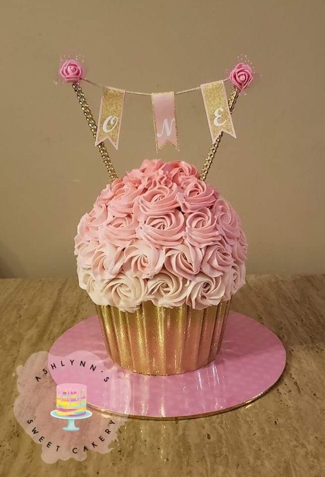 a cupcake decorated with pink frosting and roses