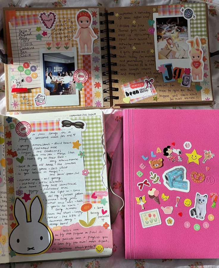 three notebooks with pictures and stickers on them are laying next to each other