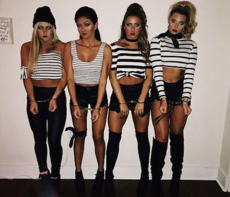 four girls in black and white outfits standing next to each other with their hands on their hipss