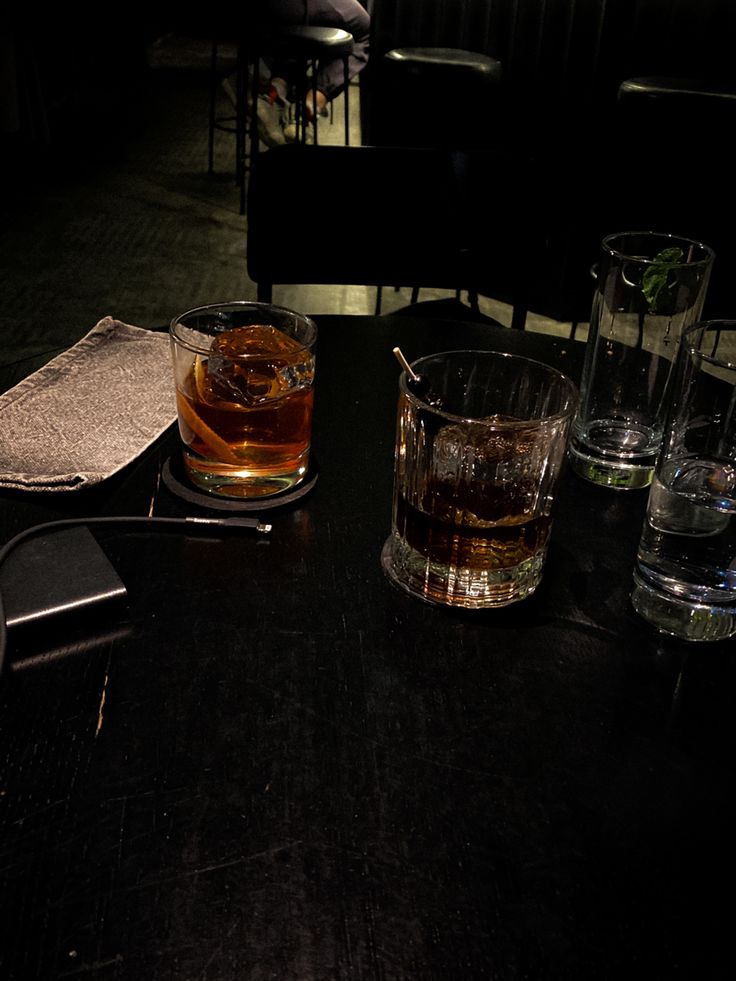 two glasses of alcohol sit on a table