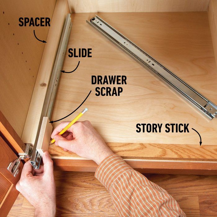 a person is holding a pencil and measuring the width of a drawer in order to measure it