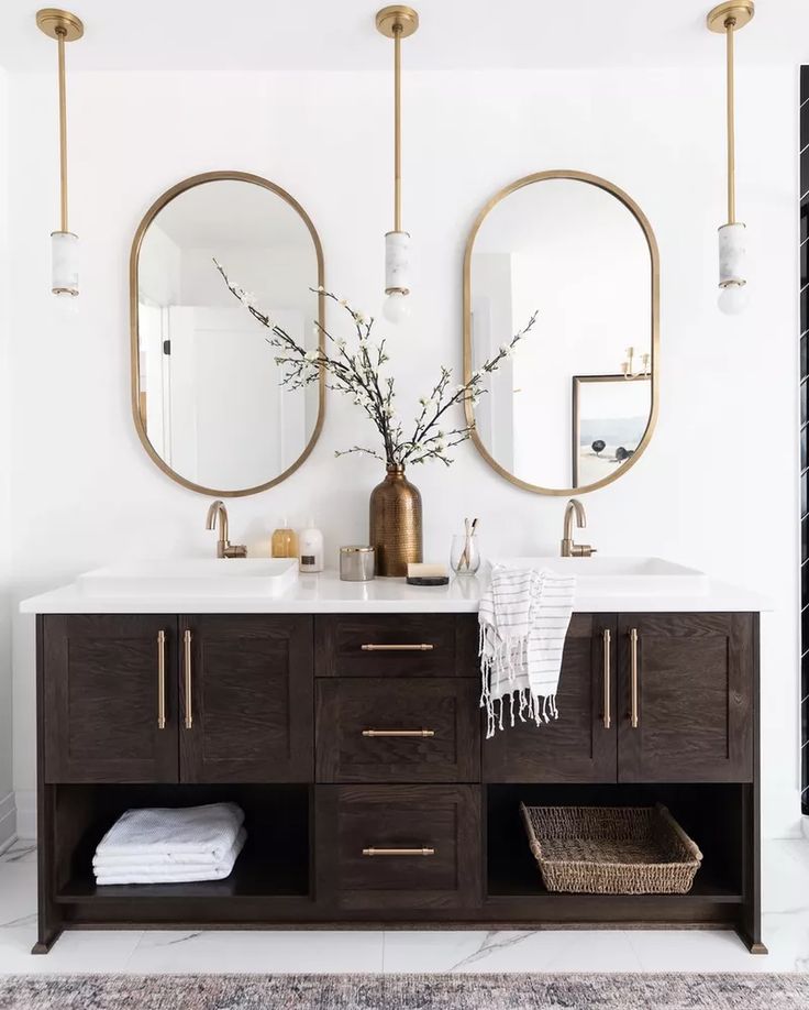 a bathroom vanity with two mirrors above it and a rug on the floor next to it