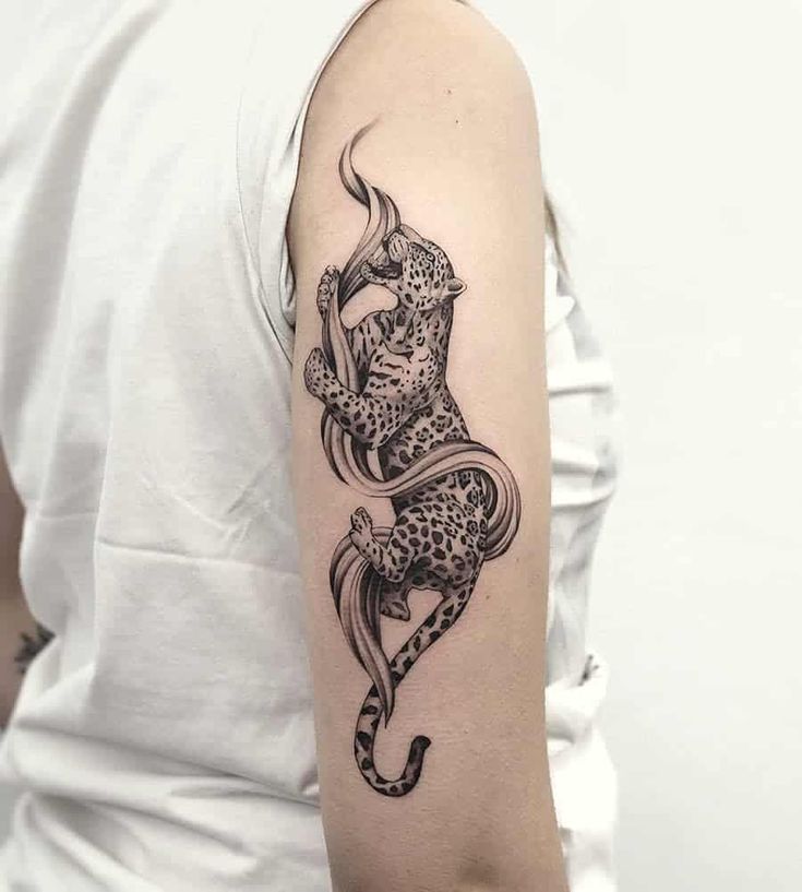 a woman's arm with a black and white tattoo of a leopard on it