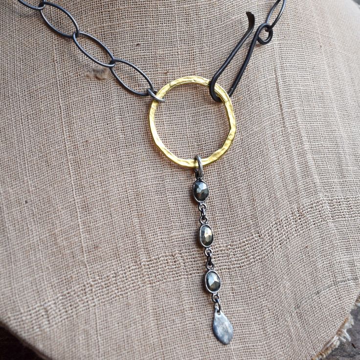 This is an artisan hammered Gold vermeil ring with a bezeled Pyrite chain pendant on matte Gunmetal with a Iron front hook enclosure. The necklace is approximately 16 1/2 inches long and the ring & chain pendant add another 3 1/4 inches. Oxidized Metal Oval Link Necklaces, Metal Necklaces With Oxidized Finish And Oval Link, Adjustable Artisan Hammered Necklace, Oval Link Metal Necklace With Oxidized Finish, Artisan Brass Necklace With Hammered Detail, Hammered Metal Jewelry With Oval Link, Artisan Hammered Adjustable Necklace, Oval Link Necklace With Oxidized Metal Finish, Hand Forged Round Metal Necklace