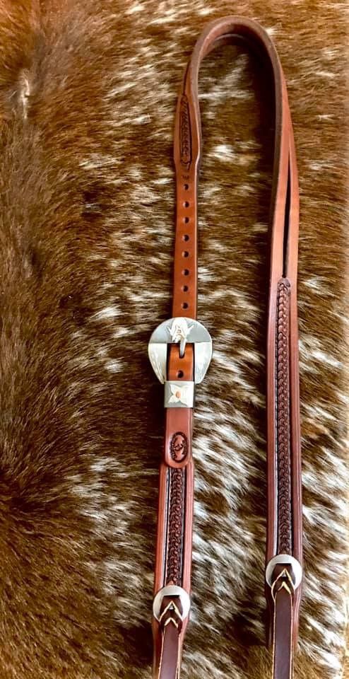 a brown and white horse's bridle on top of a fur rug