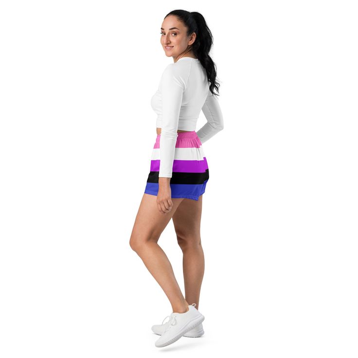 a woman standing in front of a white background wearing a skirt with multicolored stripes