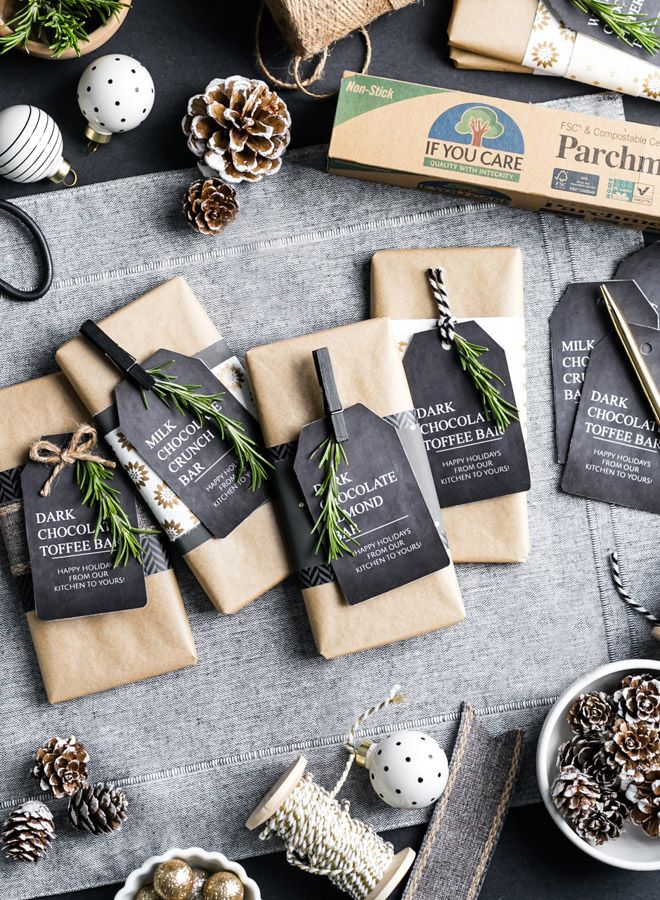 christmas presents are laid out on a table with pine cones and other holiday decorations around them