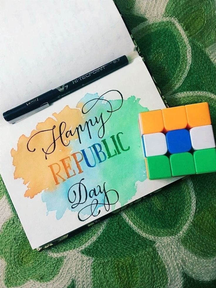 a notepad with rubic cubes and a pen on it