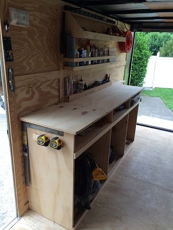 a workbench in the back of a truck with tools on it's shelves