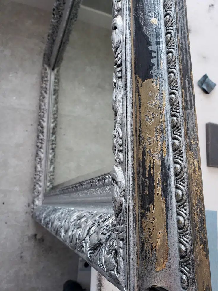 an old mirror sitting on top of a table